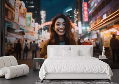 Young Asian woman holding her camera in front of the street with neon lights and buildings while looking back at camera smiling, in the city of tokyo. Wall mural