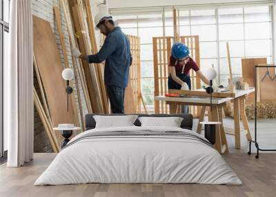 Asian male and woman carpenter working and building furniture together at wood workshop Wall mural