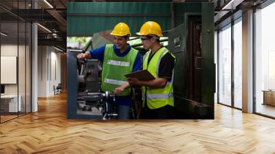 Asian male worker working with lathe machine in the factory. Male engineer worker checking, repair or maintenance machine in the factory. Male worker wearing safety uniform, helmet and gloves at work Wall mural