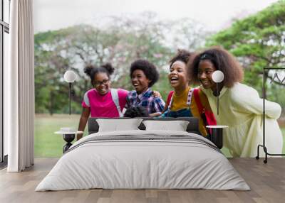 Cheerful African American children standing in row straight and hugging shoulder. diverse black children hugging shoulder in the park. Successful and teamwork concept Wall mural