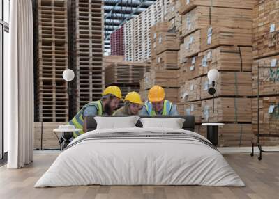 Group of male and female warehouse workers working laptop computer at wooden warehouse storage. Team of warehouse workers discussing and training of work at shelves pallet warehouse Wall mural