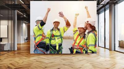 Group of male engineer standing and join their hands together at wind turbines farm, planing maintenance of wind turbines Wall mural