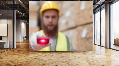 Male warehouse worker working and scanning barcode of products in wooden warehouse storage. Male construction worker at wooden warehouse Wall mural