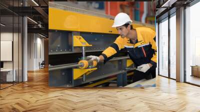 Manufacturing industrial in plant. Male engineer worker checking, repair and maintenance conveyor belt machine at manufacturing production lines in industry factory while use digital tablet Wall mural