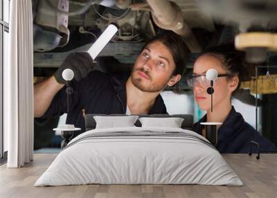 Team technician worker checking maintenance car engine underneath lifted car. Group of mechanic vehicle using wrench tool for maintenance car at automative motor garage Wall mural