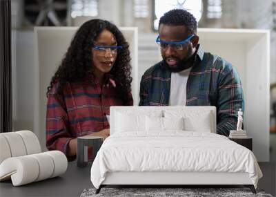 Two African American male and female carpenter working and discussing design new furniture at wood factory Wall mural