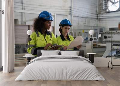 Two female engineer worker working and planing of work in industry factory. Group of female workers in the factory Wall mural