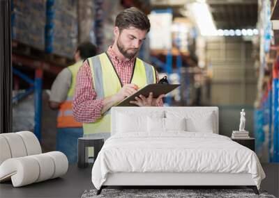 Warehouse concept. Two male warehouse worker working and checking boxes of products on shelf in warehouse. Group of two male worker at warehouse Wall mural