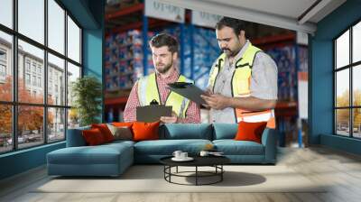 Warehouse concept. Two male warehouse worker working and checking boxes of products on shelf in warehouse. Group of two male worker at warehouse Wall mural