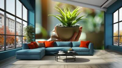 Bringing Nature Indoors - Close-up of Hand Holding Houseplant in New Home Wall mural