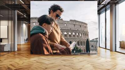 Mother and daughter looking at a map of the city,  the woman is wearing a sunglasses and the daughter is wearing a brown jacket Wall mural