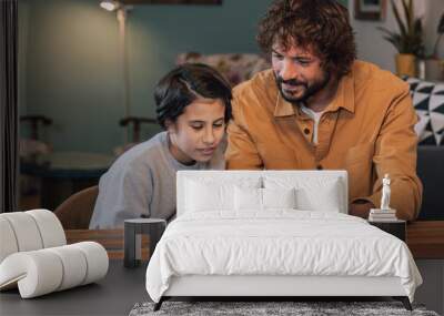 Teenage girl learning with her father using the tablet at home  Wall mural