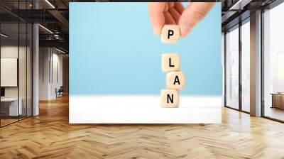 Hand hold wooden cube with PLAN word. The concept of planning in business. Wall mural