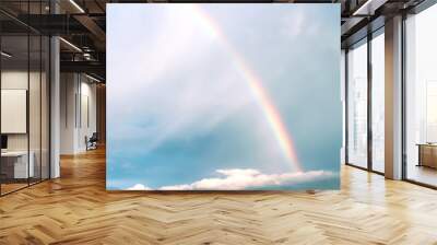 Rainbow on white cloud blue sky background after rain Wall mural