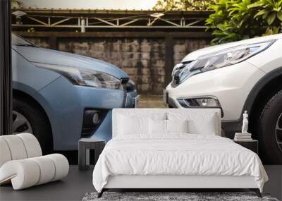 Closeup of blue and white cars parking front to front beside the street after raining, Wall mural