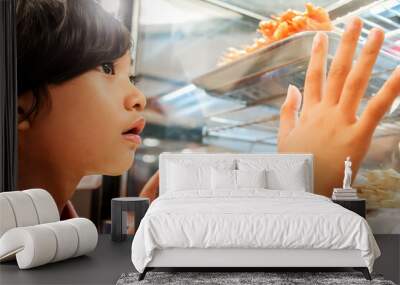 Asian little boy showing interest in snacks displayed at a local satay stall window Wall mural