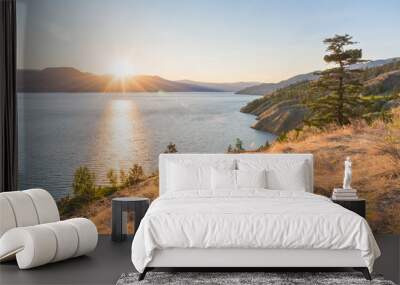 sun setting behind mountains on okanagan lake on summer evening on naramata bench Wall mural