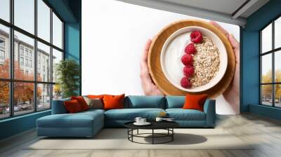 a wooden plate holds a white backdrop for a bowl of yogurt topped with raspberries and oatmeal Wall mural