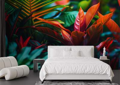 Lush tropical leaves background with vibrant dark green and crimson foliage. Wall mural