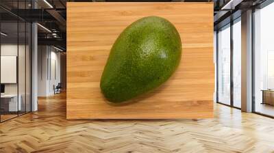 Whole green avocado fruit on a wooden surface Wall mural