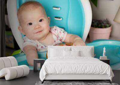 Baby eating broccoli. Baby-led weaning. Weaning. Healthy eating. Caucasian baby girl sitting in a high chair and eating her lunch
 Wall mural