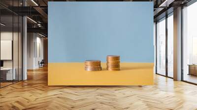 Two stacks of coins on a blue background. Financial concept. Wall mural