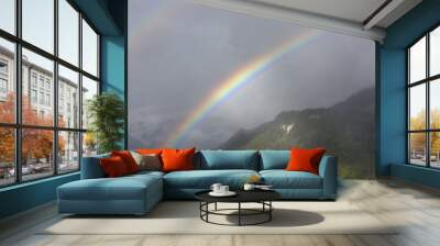 Double rainbow over misty forested hills in Switzerland. Wall mural