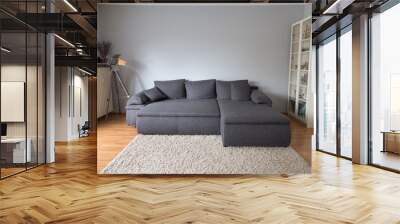 Living room with a large gray sofa bed, a carpet, a lamp and a cabinet Wall mural