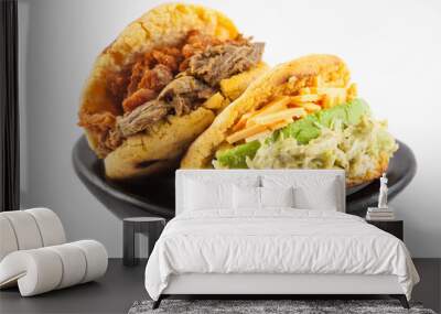 Arepas with two different fillings served in a black ceramic dish on white background Wall mural