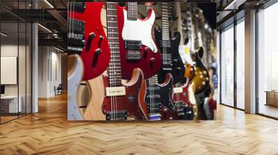 Many electric guitars hanging on wall in the shop. Wall mural