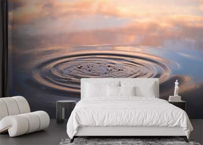 Water drop falling on water surface in evening  sunlight with reflection Wall mural