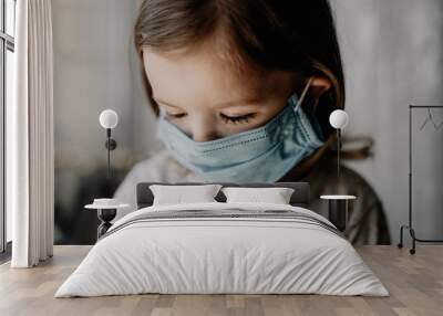 a young child wearing a protective medical mask is home treated at home Wall mural