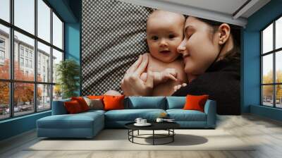 portrait of a cute baby and her mom holding a baby in her mother's arms Wall mural