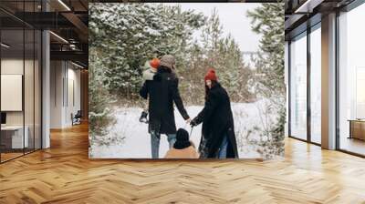 Winter holidays and people concept - happy family with little daughters choosing Xmas tree at forest. Happy preparation for the celebration of New Year holidays, family portrait on the walk Wall mural