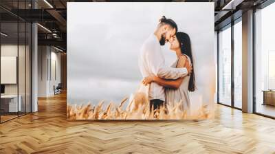 Young couple in love outdoor.Stunning sensual outdoor portrait of young stylish fashion couple posing in summer Wheat Field. selective focus Wall mural