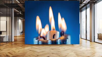 Flame of many candles burning blue background blue  Wall mural