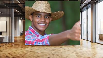 A cheerful young Black man in a straw hat playfully poses outdoors, radiating joy and energy Wall mural