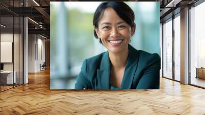 A confident Asian woman in a green blazer smiles, radiating success and positivity Wall mural