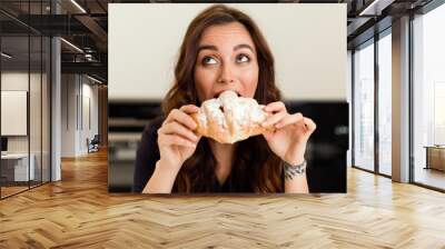 Attractive brunette woman biting fresh delicious croissant. Housewife concept Wall mural