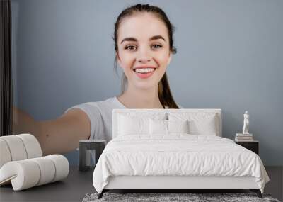 beautiful brunette girl wearing white shirt making selfie isolated over grey Wall mural