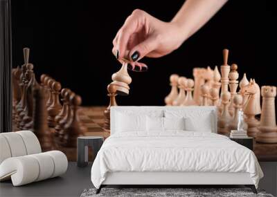 female hand making a move with a pawn on a chessboard on a black background Wall mural