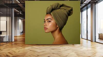 Girl with olive colored bath towel on her head on olive background. Girl after shower. Spa procedures. Female procedures on self-care. Cosmetic procedures.  Wall mural