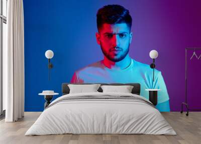 handsome bearded man in neon light posing Wall mural