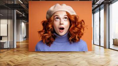 Surprised redhead woman with beret on isolated background, looking at camera, mouth open, surprised face expression, red hair color, banner for advertising Wall mural