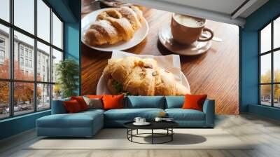 Food and drink concept. Croissant with cup of coffee on wooden table. Delicious French breakfast. Tasty food. Wall mural