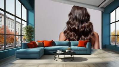 back view of a brunette woman with glossy and healthy hair on a gray background, haircare shampoo and coloration Wall mural