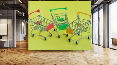 Three empty shopping cart on the yellow background Wall mural