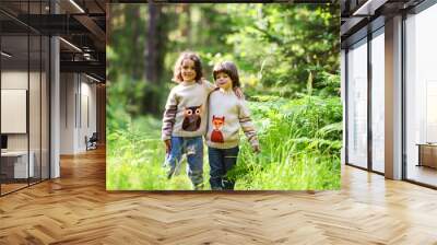 two boys are hugging in the woods. in sweaters with a fox and an owl in the summer on a sunny day Wall mural