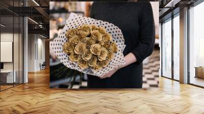 Very nice young woman holding big and beautiful mono bouquet of fresh brown roses flowers wrapped in black and white polka dotted paper  cropped photo, bouquet close up Wall mural