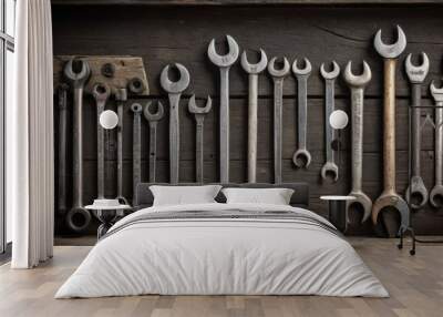 A set of vintage spanner wrenches meticulously lined up on a dark wooden surface. The image captures the aged texture and varied designs of the tools. AI generation Wall mural